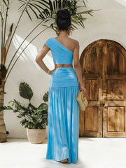 Trendsi one-shoulder top and ruched maxi skirt set, featuring a stylish off-shoulder design and fitted, ruched skirt in neutral fabric.