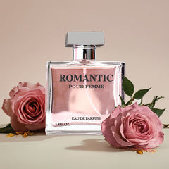 A square glass bottle of Romantic Pour Femme perfume sits between two pink roses.