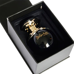 A black, apple-shaped perfume bottle with gold accents sits inside an elegant black gift box.