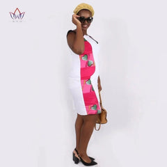 A woman wears a white knee-length bodycon dress with a pink and green patterned panel.