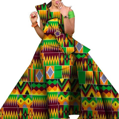 A woman wears a floor-length, off-the-shoulder dress featuring a vibrant, multicolored Kente print.