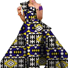 A woman wears a floor-length African print dress featuring a geometric pattern in blue, yellow, and white.