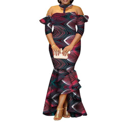 A woman wears a floor-length, off-the-shoulder African print dress with a high-low ruffled hem.