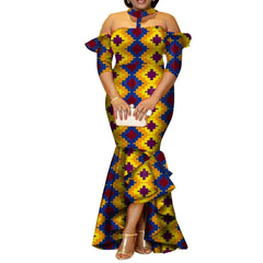 A woman wears a long, off-the-shoulder African print dress with a high-low ruffled hem.