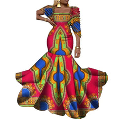 A woman wears a vibrant, floor-length African wax print mermaid dress with off-shoulder sleeves.
