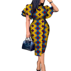 A woman wears a knee-length African wax print dress with butterfly sleeves and a geometric pattern.