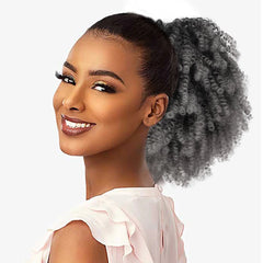A woman wears a grey kinky curly afro puff drawstring ponytail hair extension.