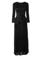 A black long-sleeved pleated dress featuring a round neck and an irregular belted waist.