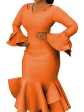 A woman wears an orange bodycon dress with cold shoulders, long flared sleeves, and ruffled hem.