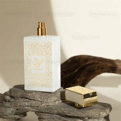 A white rectangular perfume bottle with gold Arabic calligraphy and a matching gold cap.