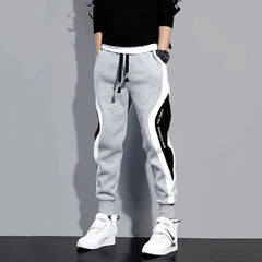 Men's grey ankle-length joggers featuring black and white side panels and an elastic drawstring waist.