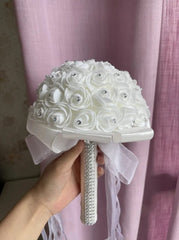 A white foam rose bridal bouquet with rhinestone centers and a crystal-embellished handle.