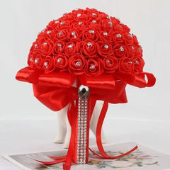 A round bridal bouquet of red foam roses accented with rhinestones and a red satin ribbon handle.