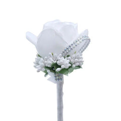 A white foam rose boutonniere accented with small white flowers and a rhinestone trim.