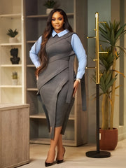 A woman wears a grey sleeveless wrap-style dress with a light blue collared shirt underneath.