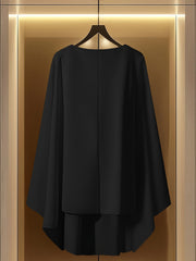 A black A-line dress with a round neck hangs on a hanger against a backlit background.