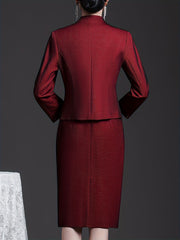 A woman wears a wine red two-piece set featuring a long-sleeved jacket and a matching skirt.