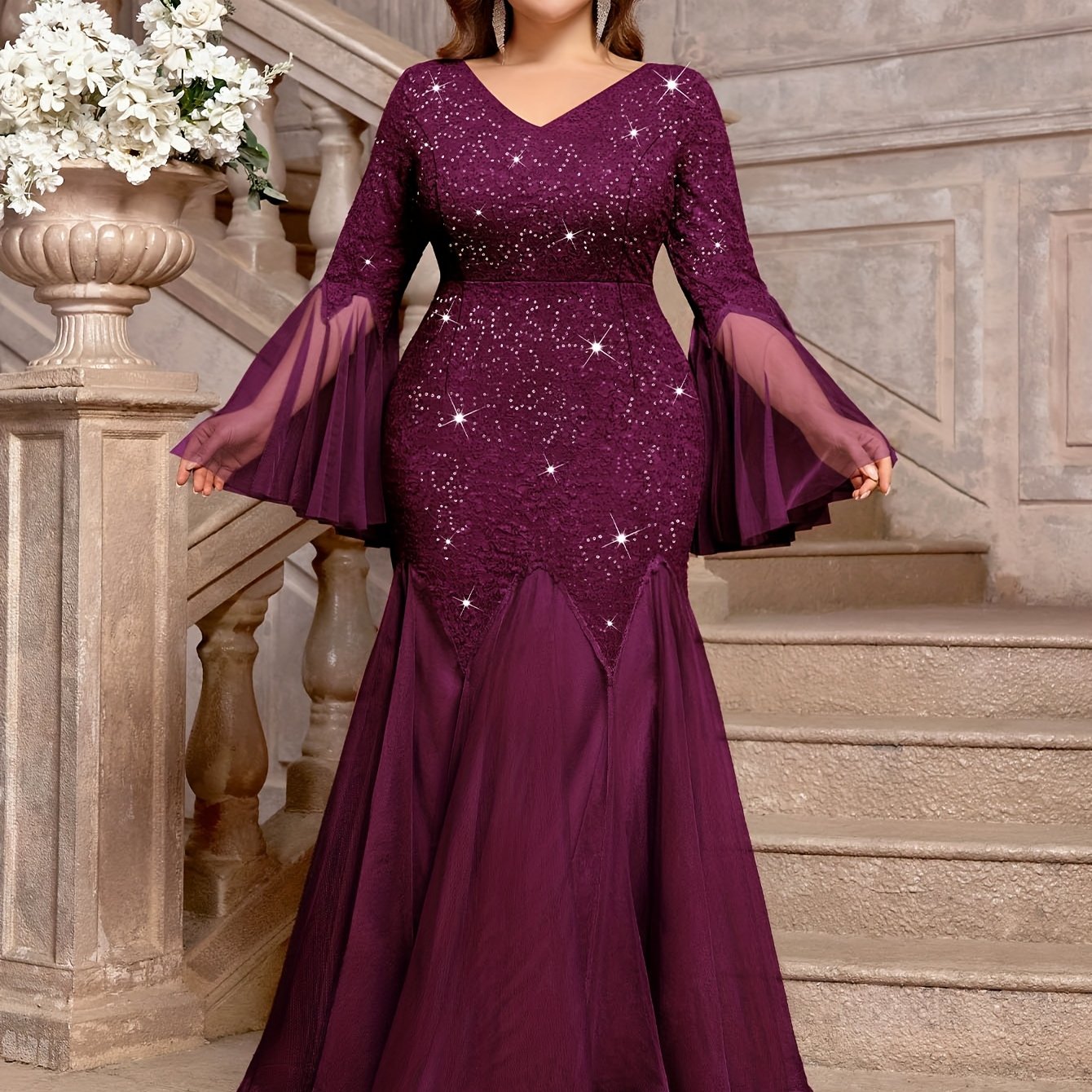 A plum-colored, floor-length mermaid gown featuring sequined lace, a V-neck, and sheer bell sleeves.