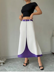 A person wears a white and purple color-block A-line skirt with a button closure.