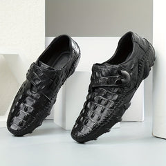Black leather loafers with a crocodile texture, hook and loop closure, and rubber soles.