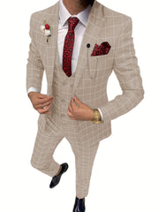 A man wears a beige plaid three-piece suit with a red patterned tie and pocket square.