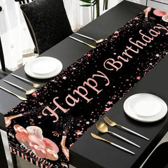 A black table runner with rose gold Happy Birthday text, stars, and balloon illustrations.