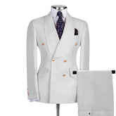 A beige double-breasted blazer and matching trousers set with gold buttons and a paisley tie.