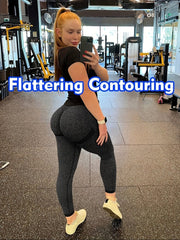 A woman wears high-waisted, seamless, butt-lifting leggings in a dark grey marl fabric.