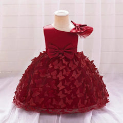 A dark red baby girl party dress featuring a tulle skirt with butterfly accents and a large bow.