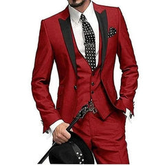 A man wears a slim-fit burgundy three-piece suit with black lapels and a polka-dot tie.