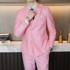 A man wears a light pink double-breasted business suit with a white shirt and blue tie.