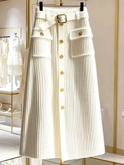 A white high-waisted midi skirt in a ribbed knit fabric with gold buttons and a matching belt.