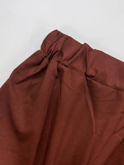 A close-up of the brown elasticated waistband on a pair of polyester casual trousers.