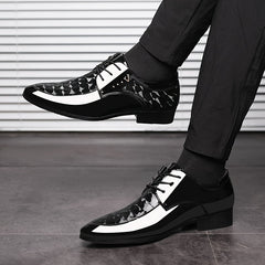 A pair of black and white pointed-toe lace-up dress shoes with a patterned finish.