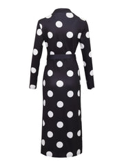 A long-sleeved black bodycon dress featuring a white polka dot pattern and a matching waist belt.