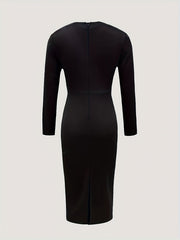 A solid black long-sleeved midi dress shown from the back with a central zipper and hem slit.