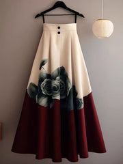 A beige and red A-line midi skirt featuring a floral print and two front buttons.