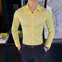 A man wears a slim-fit, long-sleeved yellow button-up shirt with a turn-down collar.