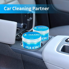 Two jars of blue Pulidiki universal dust cleaning gel sit inside a car cup holder.