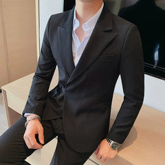 A slim-fit black blazer with a side buckle detail and lapel collar worn over a white shirt.