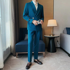 A man wears a slim-fit teal suit jacket with a side buckle detail and matching trousers.
