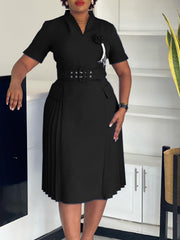 A black V-neck dress with a belted waist, short sleeves, and a pleated skirt.