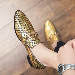 A pair of gold metallic slip-on loafers with a textured scale pattern and a decorative metal bit.