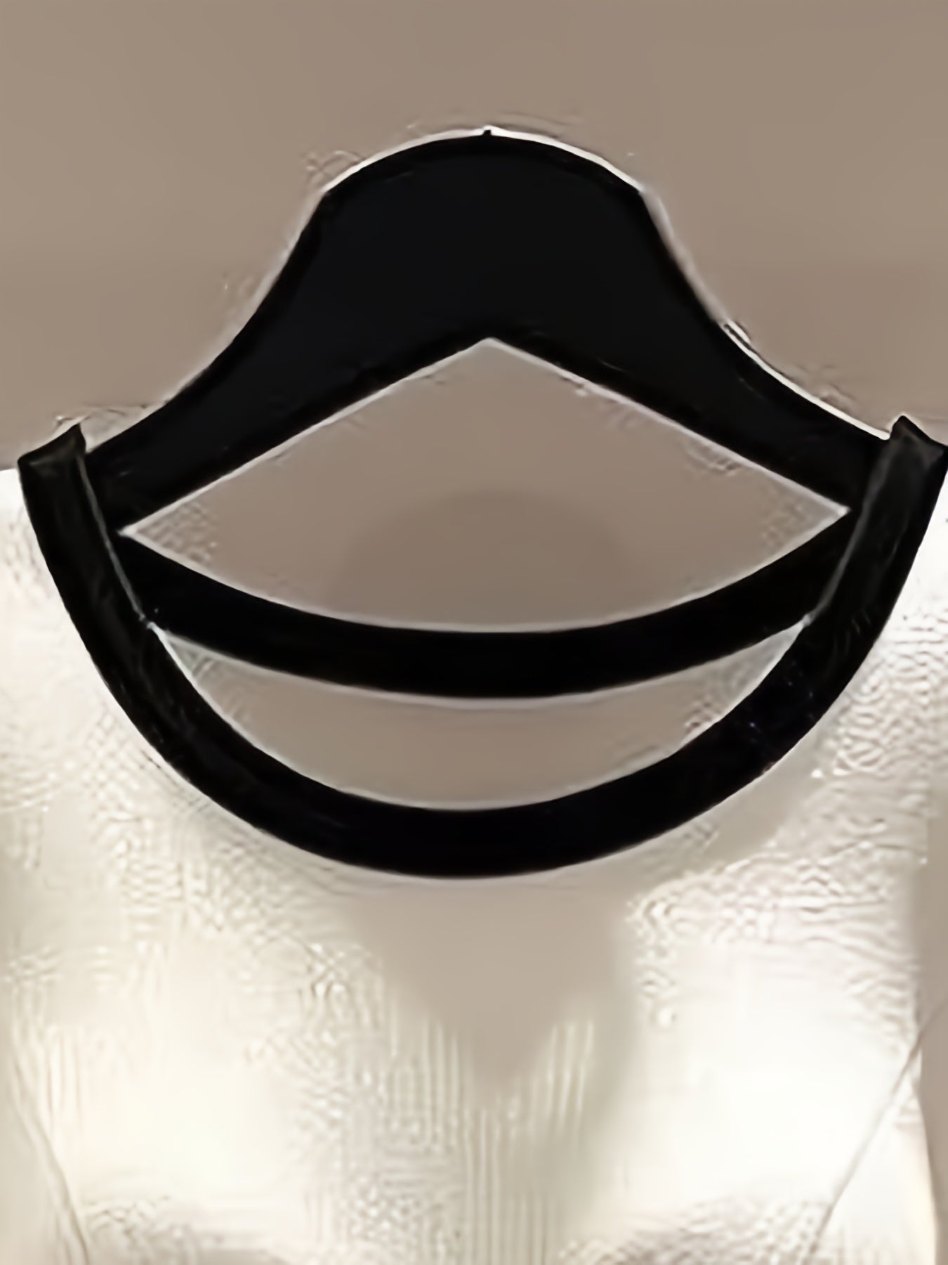 A white blouse featuring a rounded neckline with a distinctive black curved trim detail.