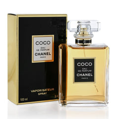 A bottle of Chanel Coco Eau de Parfum next to its black and gold box on a white background.