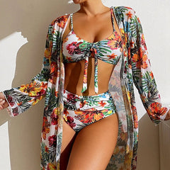 A woman wears a floral print three-piece bikini set with a matching long-sleeved mesh cover-up.