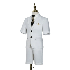 A white short-sleeved children's suit with a black tie and gold lapel pin on a mannequin.