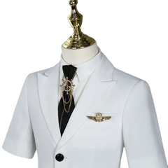 A white short-sleeved children's suit jacket with a black tie, gold ship wheel pin, and wing brooch.