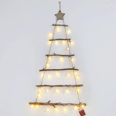 A wall-hanging DIY Christmas tree made of wooden branches decorated with warm string lights.