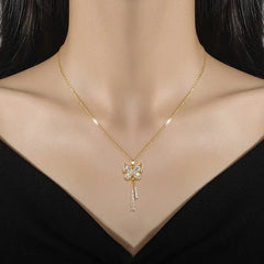 A gold-tone butterfly pendant necklace with white crystal accents and dangling tassel chains.